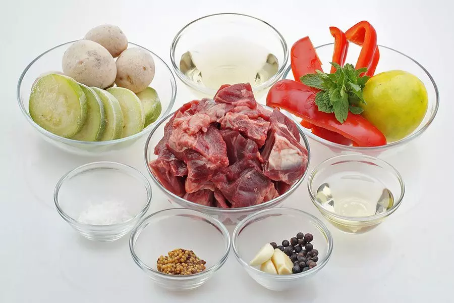 Козленка разморозить естественным способом на нижней полке холодильника. Если необходимо, крупные кусочки разрезать. Перец очистить от семенной коробки, нарезать произвольно.