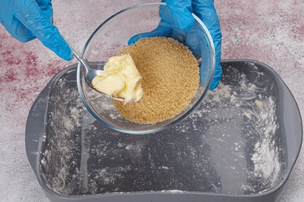 Смешать коричневый сахар с маслом и выложить на дно формы.