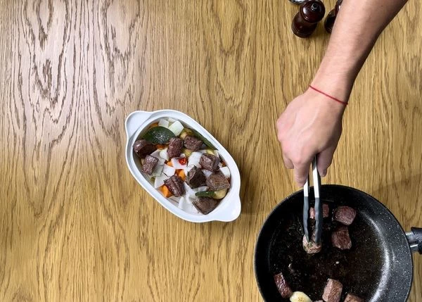 В форму для запекания выложить нарезанные овощи и обжаренное мясо. Запекать в разогретой до 180 градусов духовке в течение 90 минут.