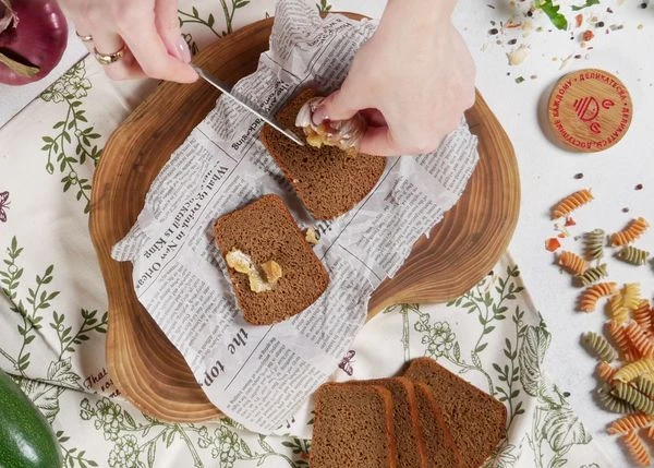 Чеснок вымыть, срезать верхнюю часть, сбрызнуть маслом, посолить, завернуть в фольгу. Запекать 15 минут при 180 градусах. 
Ломтик хлеба смазать запеченным чесноком.