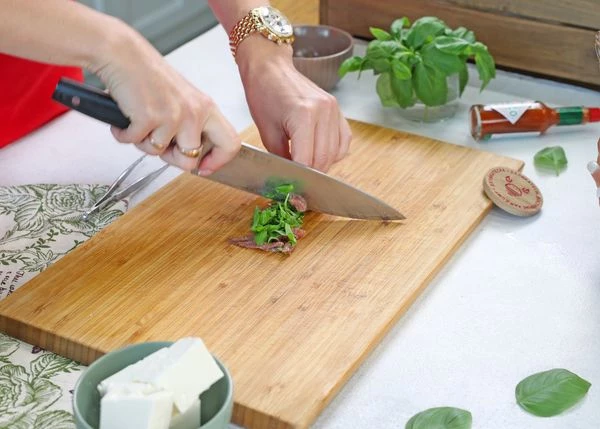 Филе анчоусов нарезать вместе с листьями базилика.