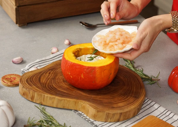 Добавить листочки розмарина и размороженные креветки. Посолить. Поставить в разогретую до 180 градусов духовку на 40-50 минут. Запекать до мягкости тыквы. 