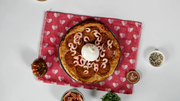 Креветки разморозить, почистить. Пирог переложить на тарелку для подачи. Выложить на него очищенные креветки. В центр выложить буррату. 