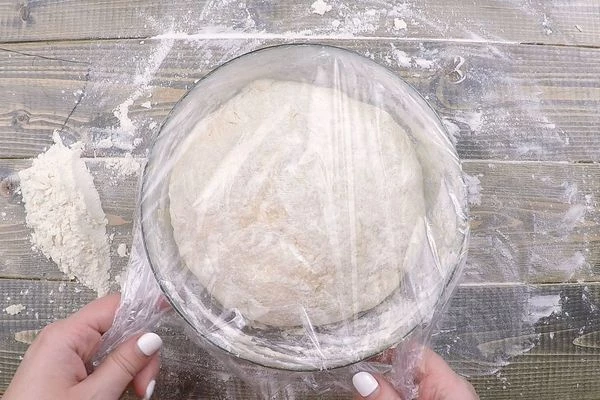 Сформовать в шар, накрыть пищевой пленкой и оставить в теплом месте, чтобы «подошло» часа на два. Периодически необходимо обминать тесто, выпуская лишние пузырьки с воздухом.