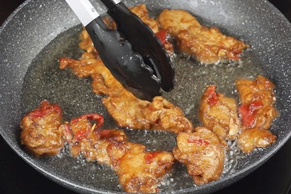 На разогретой с растительным маслом сковороде обжарить мясо до румяной корочки, переложить на бумажное полотенце, чтобы стекли излишки масла.