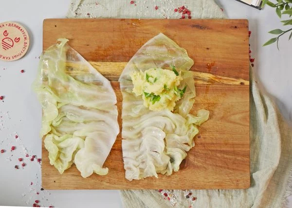 В кочане капусты удалить кочерыжку. В кастрюле вскипятить воду, слегка посолить. В кипящую воду опустить капусту. Довести до кипения. Варить до мягкости самого нижнего листа, около 1 минуты. Лист снять, переложить на доску. Отварить еще 4-5 листов. Если листья крупные, разрезать пополам, удалив грубую прожилку. На половину капустного листа выложить картофельное пюре и завернуть. 

