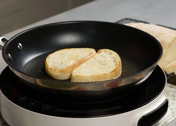 Чиабатту нарезать на ломтики, обжарить на оливковом масле. 