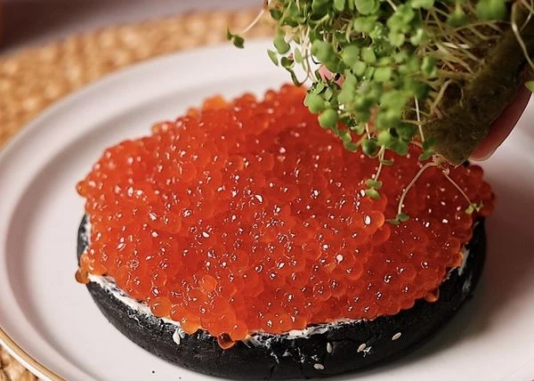 Выложить на булочку икру. Посыпать микрозеленью.
