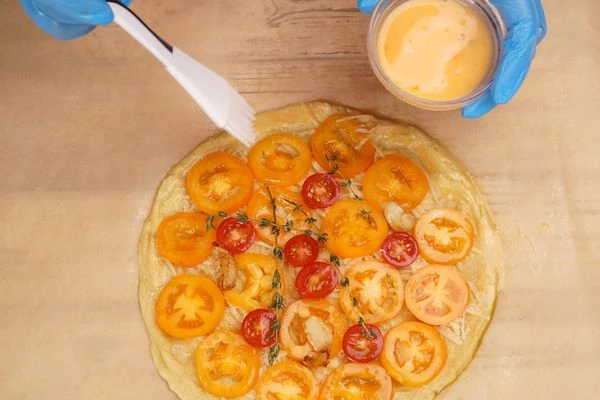 Тесто по краю смазать взбитым яйцом.
Поставить в разогретую до 200С духовку примерно на 30-35 минут.
