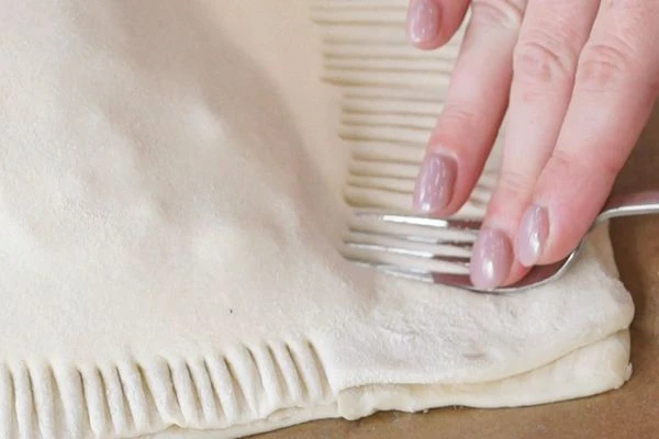 Вилкой защипнуть края теста.
