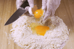 Добавьте яйца и замесите мягкое тесто.