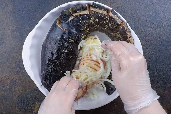 Выложить в форму для запекания. В центр уложить нарезанный тонкими пластиками картофель и нарезанный соломкой лук. 