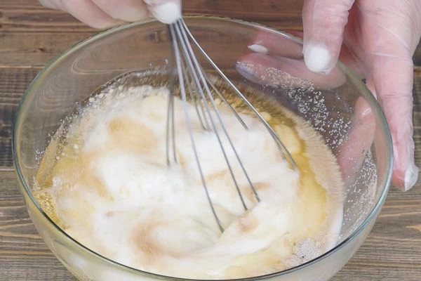 В глубокой чашке смешать воду, кефир, растительное масло, соль, сахар, дрожжи, яичный белок от 2 яиц, хорошо перемешать.