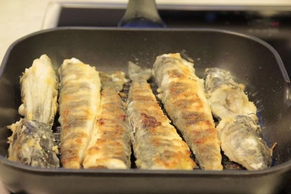 Обжарить на раскаленной сковороде с оливковым маслом примерно 10 минут ( в зависимости от размера рыбы). Подать с зеленью и помидорами черри.