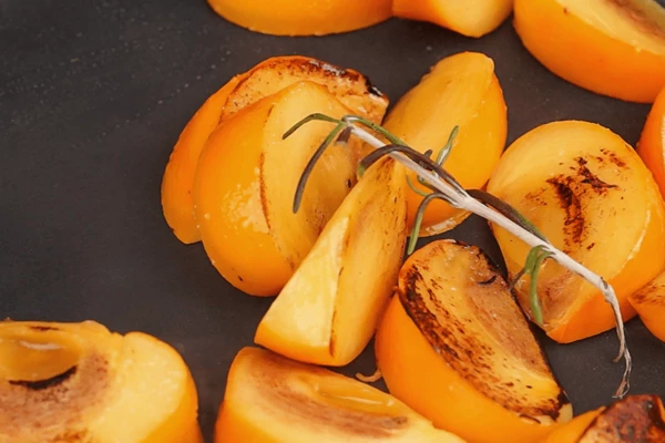 Хурму нарезать дольками, обжарить на разогретой сковороде. Если хурма не сладкая, то добавить пару чайных ложек меда. Когда хурма приобретет аппетитный румяный колер, влить 1/2ч.л винного уксуса.