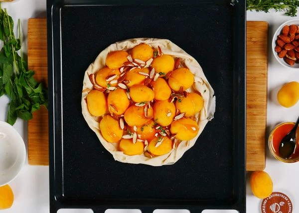 Посыпать нарезанным миндалем и листочками тимьяна. Полить медом. Поставить в разогретую до 180 градусов духовку на 15 минут. 