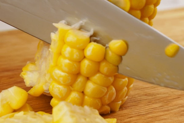 Кукурузу очистить, ножом срезать зерна с початка.