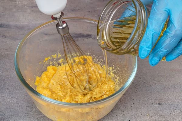 Взбить венчиком, постепенно добавляя растительное масло (150 мл).