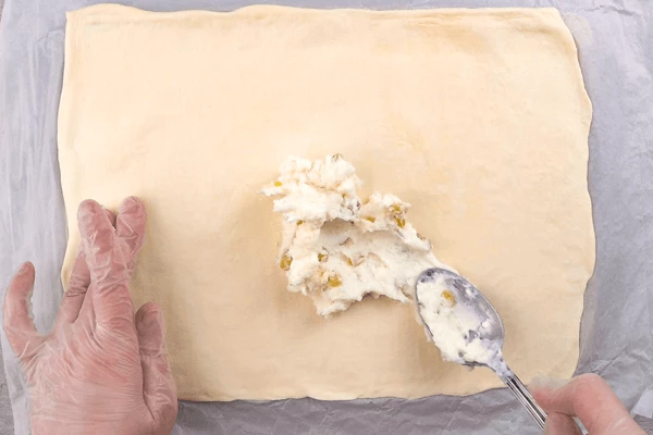 Выложить тонким ровным слоем творожную массу, посыпать орехами. 