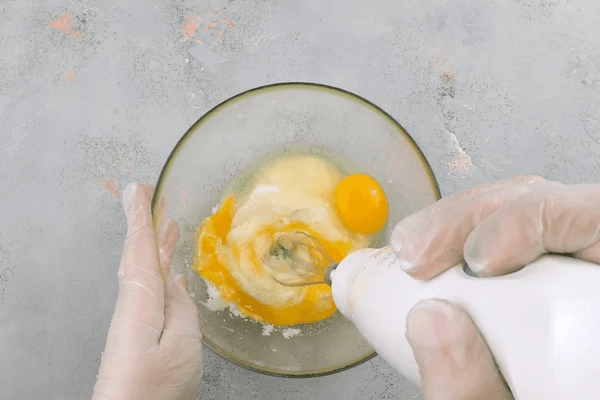 В глубокой чашке взбить венчиком яйца и сахар (150 г) в пену.