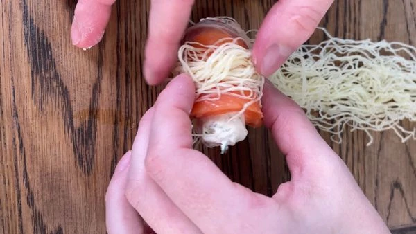 Тесто разморозить на нижней полке холодильника, разделить на равные части (10). Каждый рулетик из чавычи завернуть в тесто. 