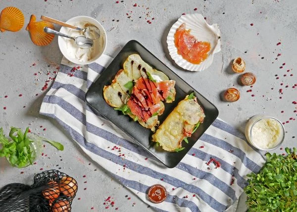 Затем рукколу, и ломтики форели. Полить соусом и сложить лепешку пополам. 
