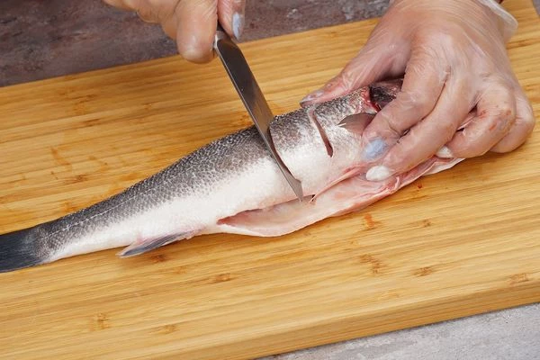Рыбу почистить, промыть под проточной водой. Очистить от чешуи, удалить внутренности. Обсушить бумажным полотенцем и сделать с каждой стороны несколько глубоких надрезов. 