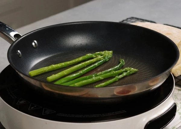 Спаржу разморозить на нижней полке холодильника. На этой же сковороде обжарить спаржу, выключить нагрев и добавить устричный соус, посолить. 
