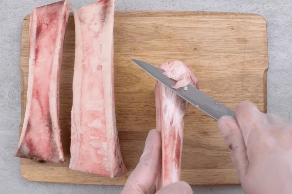 Кости разморозить естественным способом на нижней полке холодильника. Зачистить от хрящей и жилок, если есть необходимость.