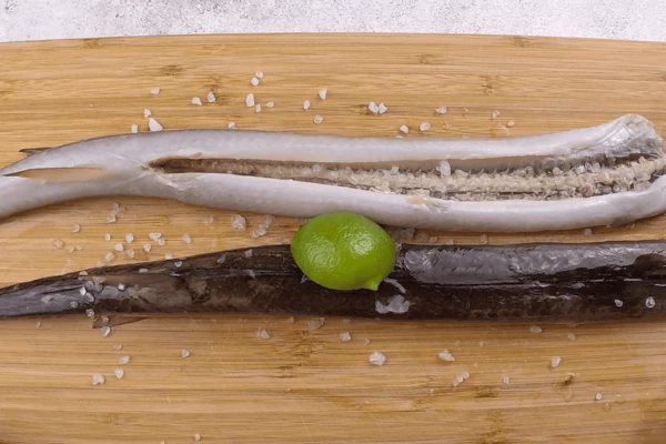  Рыбу разморозить естественным способом на нижней полке холодильника, промыть под проточной водой, натереть соком лайма и крупной солью. Оставить на 15-20 минут. Затем промыть под холодной водой.