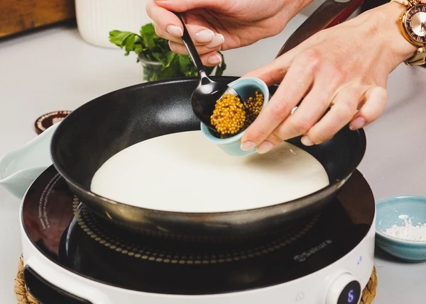 В это время приготовить соус. Для этого в сковороду влить сливки, добавить горчицу, соль, довести до кипения. Снять с огня. 