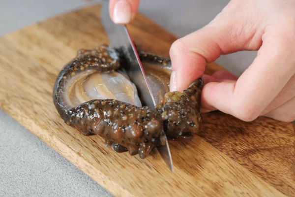 Трепанга разрезать вдоль туловища на две части, удалить все внутренности и маленькие зубки, которые находятся в условно передней части трепанга. Промыть в холодной проточной воде.