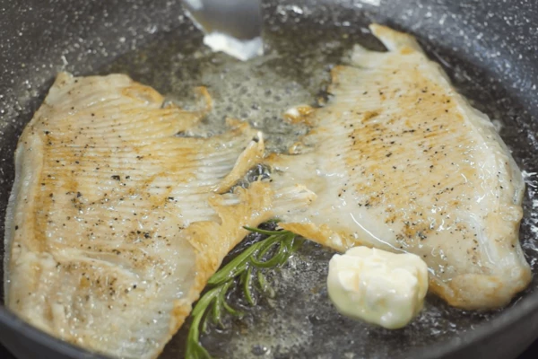 Обжарить с двух сторон на оливковом масле с розмарином, добавить соль, перец черный молотый. В самом конце добавить сливочное масло, растопить его и полить крылья сверху. Крылья ската переложить на тарелку. 