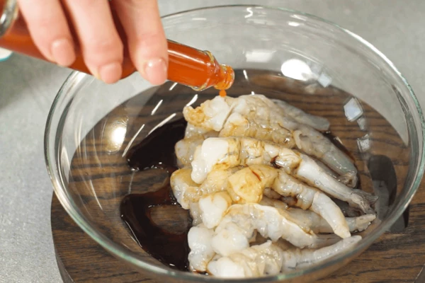 Переложить в салатник, залить соевым соусом, добавить пару капель табаско и перемешать. Оставить мариноваться 30 минут.
