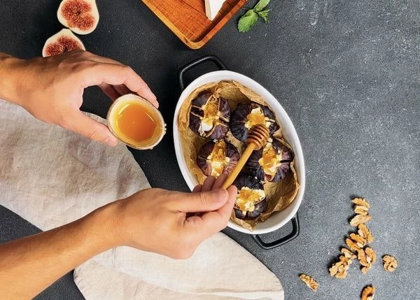 Полить медом. Поставить форму с инжиром в разогретую до 180 градусов духовку и запекать в течение 8-10 минут, пока камамбер не станет мягким и орехи не приобретут золотистый оттенок. 