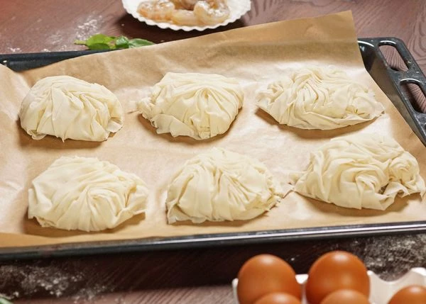 Выложить на противень с пергаментом. Смазать взбитым яйцом. Выпекать в разогретой до 180 градусов духовке в течение 10 минут. 