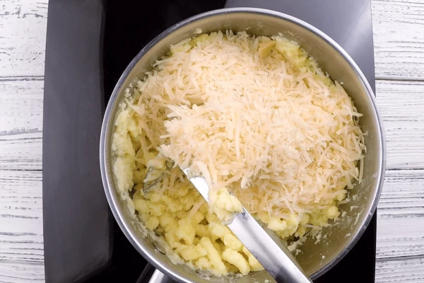 Хорошо перемешать, добавить тертый сыр. Накрыть крышкой и оставить в теплом месте.