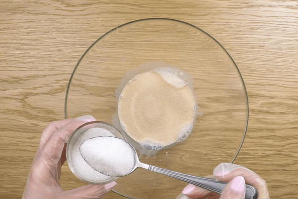 Теплое молоко (около 40 С) смешать с 1 ст.л сахара, добавить дрожжи, размешать и поставить в теплое место до образования пены. Этот процесс можно немного ускорить, поставив чашку над кастрюлей с теплой водой.