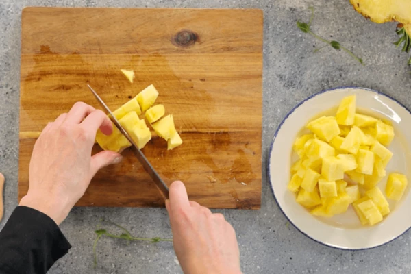Мякоть выложить на доску, срезать сердцевину. Мякоть нарезать средним кубиком.