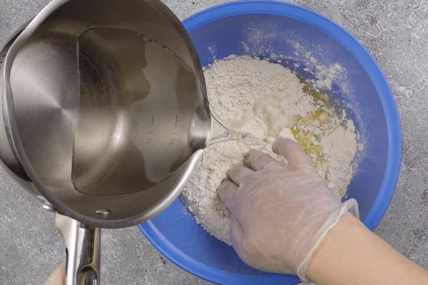 Сделать тесто: смешать муку, дрожжи, соль, сахар, оливковое масло, добавить теплую воду и замесить мягкое тесто. 