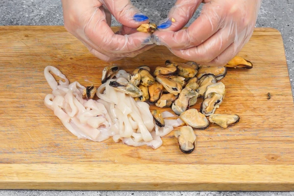 Мидии проверить на остатки нити биссуса, если необходимо, удалить. Кальмар нарезать полосками. 