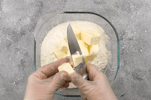 Для теста смешать в глубокой чашке муку, нарезанное сливочное масло, соль.