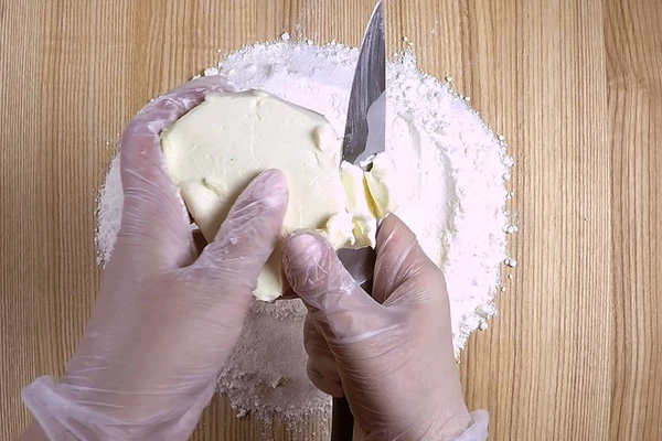 Муку смешать с сахаром, затем добавить нарезанное сливочное масло. 