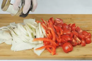 Лук и перец нарезать крупной соломкой, помидоры на 4 части. Приправить Сванской солью. 