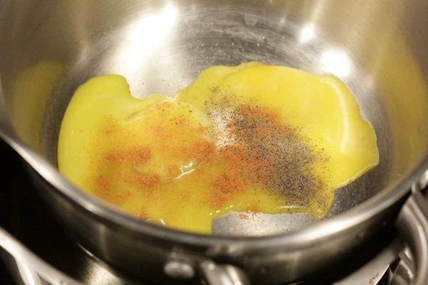 Отдельно взбить желтки с солью, черным и красным перцем, соединить с тушеным луком. Желтки необходимо вливать постепенно, интенсивно помешивая, чтобы не свернулись. Варить все на водяной бане, помешивая, добавляя понемногу размягченное сливочное масло до состояния майонеза.