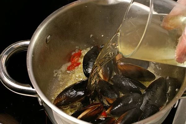 Влить белое вино и дать выпариться 1-2 минуты.