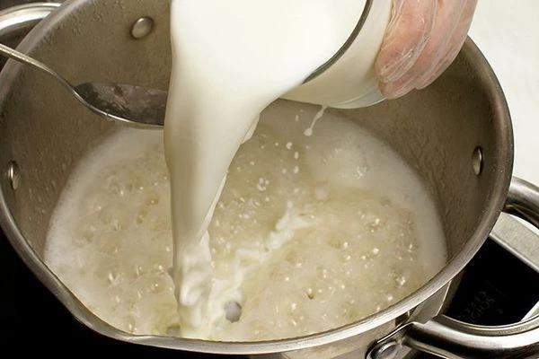 Влить молоко, варить на среднем огне до готовности риса.