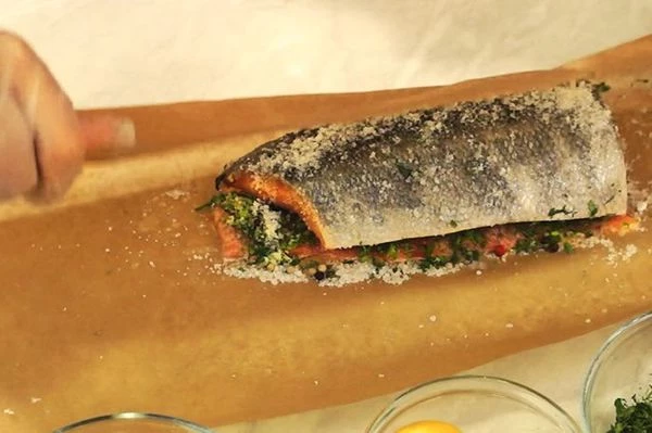 Выложить политое соком филе на зелень, кожей вверх. Завернуть плотно в пергамент. Оставить на 2 часа при комнатной температуре. Затем убрать в холодильник на 10-12 часов.