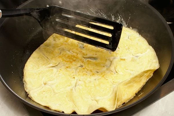 Яйца взбить венчиком. Пожарить на разогретой с растительным маслом сковороде тонкие яичные блинчики