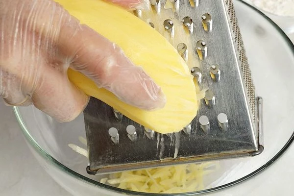 В глубокую чашку натереть на крупной терке картофель.